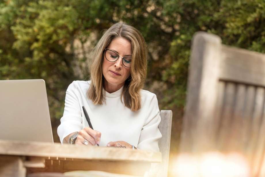 Woman Sitting on Gray Chair While Writing 