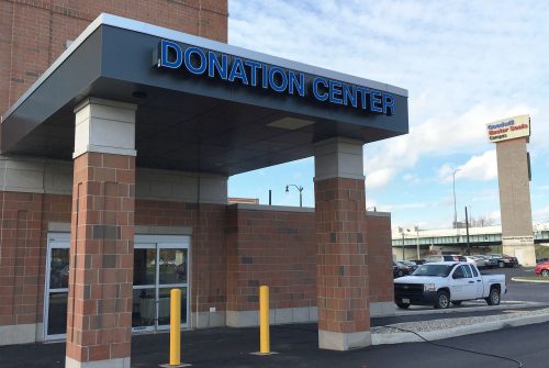 Goodwill donation center overhang on brick pillars, attached to a building.