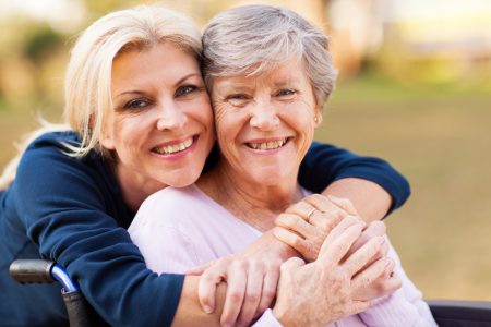 Middle aged woman hugging her senior mother